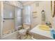 Bathroom with a shower, toilet with safety rails, yellow sink, and decorative wallpaper at 7133 El Matador St, Zephyrhills, FL 33541
