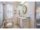 Bathroom features a shower, toilet with safety rails, decorative wallpaper, and a yellow sink at 7133 El Matador St, Zephyrhills, FL 33541