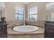 Luxurious bathroom showcasing a large soaking tub with tile surround and modern fixtures at 8414 Eagle Brook Dr, Land O Lakes, FL 34638