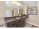 Bathroom featuring a spacious vanity with granite countertop and a mirror reflecting a shower with glass door at 8414 Eagle Brook Dr, Land O Lakes, FL 34638