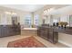 Expansive bathroom with dual vanities, a soaking tub, and ample space accentuated by a striking red rug at 8414 Eagle Brook Dr, Land O Lakes, FL 34638