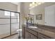 Bathroom featuring granite counters, dark cabinets, and a glass enclosed shower at 8414 Eagle Brook Dr, Land O Lakes, FL 34638