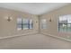 Neutral bedroom with carpeted floors, two windows, sconce lighting and base molding at 8414 Eagle Brook Dr, Land O Lakes, FL 34638