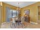 This elegant dining room features a chandelier, wainscotting, a window, and neutral paint at 8414 Eagle Brook Dr, Land O Lakes, FL 34638