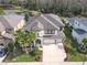 Beautiful two-story home with a three-car garage, lush landscaping, and front yard at 8414 Eagle Brook Dr, Land O Lakes, FL 34638
