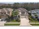 Beautiful two-story home with a three-car garage, well-maintained landscaping, and palm trees at 8414 Eagle Brook Dr, Land O Lakes, FL 34638