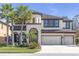 Stunning two-story home with a three-car garage and lush landscaping featuring mature palm trees at 8414 Eagle Brook Dr, Land O Lakes, FL 34638