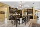 Elegant kitchen featuring a large island with seating, dark cabinetry, and modern appliances at 8414 Eagle Brook Dr, Land O Lakes, FL 34638