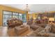 Spacious living room with elegant chandelier, tile floors, stylish furniture, and sliding glass doors to the pool at 8414 Eagle Brook Dr, Land O Lakes, FL 34638