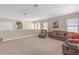 Neutral-colored living room showcasing a comfortable leather sofa, chair and bright natural light from the windows at 8414 Eagle Brook Dr, Land O Lakes, FL 34638