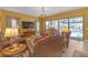 Cozy living room featuring a chandelier, plush seating, and views of the screened-in pool area, ideal for relaxation at 8414 Eagle Brook Dr, Land O Lakes, FL 34638