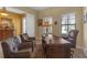 Well-lit office features a stately wooden desk and comfortable leather chairs, ideal for a productive workspace at 8414 Eagle Brook Dr, Land O Lakes, FL 34638