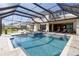Screened-in pool area with a hot tub, view, and ample seating at 8414 Eagle Brook Dr, Land O Lakes, FL 34638