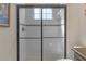 White tiled shower features glass doors, dark accents, and a shower bench at 8414 Eagle Brook Dr, Land O Lakes, FL 34638