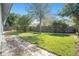 A large, grassy backyard with a stone walkway and a wooden fence for privacy at 858 Harbor Hill Dr, Safety Harbor, FL 34695