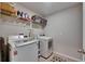 Bright laundry room with white washer and dryer, shelving for storage, and tiled floor, perfect for efficient chores at 9715 Sage Creek Dr, Ruskin, FL 33573