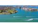 Aerial view of the beautiful community surrounded by the turquoise bay and boats cruising on the open water at 10355 Paradise Blvd # 909, Treasure Island, FL 33706