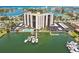 An aerial view of the waterfront condo building with docks, boat slips, swimming pool, and covered parking at 10355 Paradise Blvd # 909, Treasure Island, FL 33706