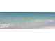 Calm beach with clear, turquoise water gently lapping onto the shore, creating a peaceful waterfront scene at 10355 Paradise Blvd # 909, Treasure Island, FL 33706