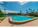 Community pool with a clear blue sky view, and lush landscaping at 10355 Paradise Blvd # 909, Treasure Island, FL 33706