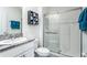 Clean bathroom with a glass-enclosed shower, modern vanity with granite countertop, and stylish décor accents at 10759 Penny Gale Loop, San Antonio, FL 33576