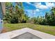 A concrete patio extends out into a lush, green backyard at 1119 77Th N St, St Petersburg, FL 33710