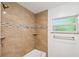 Bathroom featuring a tiled shower, neutral accents, and a window with natural light at 1119 77Th N St, St Petersburg, FL 33710
