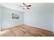 Bright bedroom with wood-look flooring, ceiling fan, and large window at 1119 77Th N St, St Petersburg, FL 33710