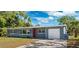 Charming single-story home with a well-maintained lawn and a red front door at 1119 77Th N St, St Petersburg, FL 33710