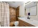 Bathroom featuring a shower with brown tile surround and a single sink vanity with white countertop at 11407 3Rd N St # 1, St Petersburg, FL 33716