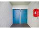 Double blue doors lead to individual units with fire safety box at 11407 3Rd N St # 1, St Petersburg, FL 33716