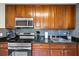 Modern kitchen featuring wooden cabinets, granite countertops, stainless steel appliances, and tile backsplash at 11407 3Rd N St # 1, St Petersburg, FL 33716