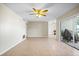 Open living room with tile floors, neutral walls, ceiling fan, and sliding glass doors to an outdoor area at 11407 3Rd N St # 1, St Petersburg, FL 33716