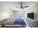 Main bedroom with ceiling fan, patterned rug, and a full-size bed under a large window at 11407 3Rd N St # 1, St Petersburg, FL 33716