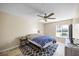 Main bedroom with ceiling fan, a patterned rug, and a full-size bed under a large window at 11407 3Rd N St # 1, St Petersburg, FL 33716
