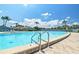 Community swimming pool with blue skies, palm trees, and pool ladder at 11407 3Rd N St # 1, St Petersburg, FL 33716
