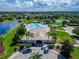 Aerial view of a community pool with palm trees, lounge chairs, and clubhouse in the distance at 11517 Weston Course Loop, Riverview, FL 33579