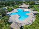 Aerial view of a uniquely-shaped community pool with a water splash feature and lounge seating nearby at 11517 Weston Course Loop, Riverview, FL 33579