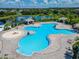Aerial view of a uniquely-shaped community pool with water features and lake views in the distance at 11517 Weston Course Loop, Riverview, FL 33579