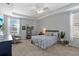 This bright main bedroom features a tray ceiling, ceiling fan, and two large windows at 11517 Weston Course Loop, Riverview, FL 33579