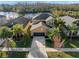An aerial view of a tan two-story home with a black roof, attached garage and lake views at 11720 Winterset Cove Dr, Riverview, FL 33579