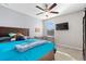Well-lit bedroom with ceiling fan, carpet, a bed, and a wooden desk at 11720 Winterset Cove Dr, Riverview, FL 33579
