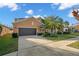 Charming two-story home featuring a well-maintained lawn, mature palm trees, and a two-car garage at 11720 Winterset Cove Dr, Riverview, FL 33579