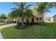 Charming two-story home with lush landscaping, stone accents, and mature palm trees at 11720 Winterset Cove Dr, Riverview, FL 33579