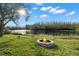 Backyard stone fire pit near lake is perfect for outdoor gathering at 11720 Winterset Cove Dr, Riverview, FL 33579