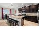 Modern kitchen with granite countertops, dark cabinets, stainless steel appliances, island and adjacent dining area at 11720 Winterset Cove Dr, Riverview, FL 33579