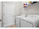 Laundry room equipped with white washer and dryer units and a wire shelf at 11720 Winterset Cove Dr, Riverview, FL 33579