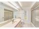 Clean bathroom with a shower/tub combo, large mirror, and natural light from a window at 1559 Overland Dr, Spring Hill, FL 34608