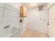 Functional laundry room with a utility sink, tile flooring, and storage shelf at 1559 Overland Dr, Spring Hill, FL 34608