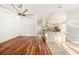 Open-concept living room showing wood and tile floors, kitchen access, and bright natural lighting at 1559 Overland Dr, Spring Hill, FL 34608
